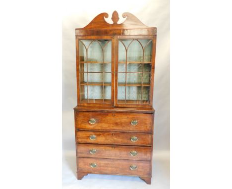 An early 19thC mahogany secretaire bookcase, the top with a swan neck pediment, centred with a stylised apron, above two astr