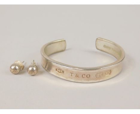 Two items of silver jewellery, to include a Tiffany and Co stamped bangle marked 1997, and a pair of silver Tiffany and Co st