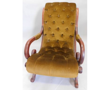 A 20thC mahogany open chair, in button back gold coloured material with heavy scroll arms on scroll feet, 91cm high