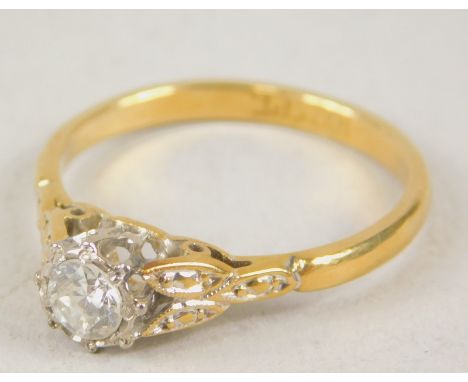 An early 20thC diamond solitaire ring, florally claw set on a fancy part pierced shank, yellow metal marked 18ct, 2.1g all in