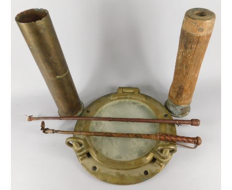 A brass ship's port hole, two dummy artillery type shells and two riding crops