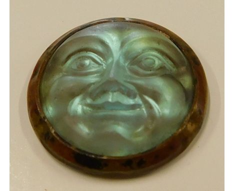 A Czechoslovakian saphiret moonface, in gilt metal surround, on material backing, 2cm wide
