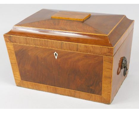 A 19thC mahogany and rosewood crossbanded sarcophagus shaped tea caddy, with lion mask side handles, interior adapted, 29cm w