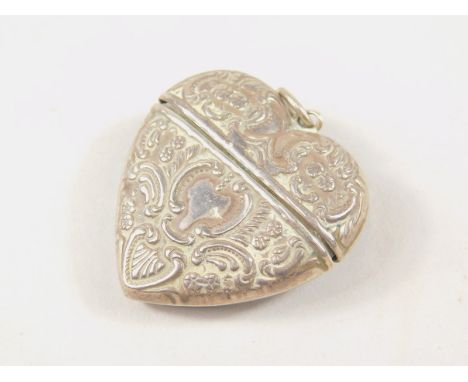 An early 20thC miniature heart shaped case, the heavy repousse decorated body with a vacant cartouche, flanked by ring handle