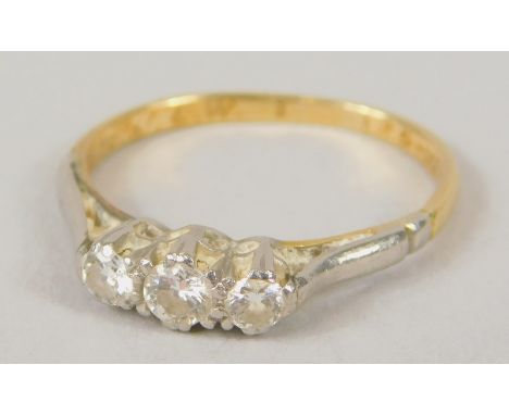 A dress ring, set with three claw set tiny diamonds, in platinum setting, on a yellow metal band, unmarked, misshaped, 1.9 gr