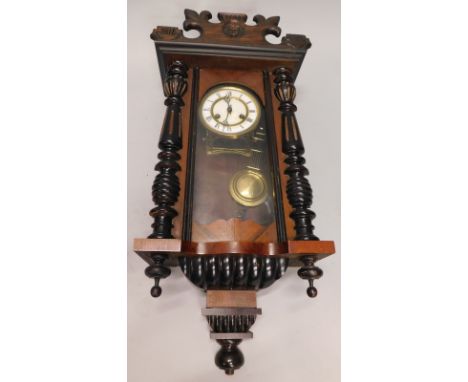 A late 19th/early 20thC Vienna wall clock, in a walnut case with enamel dial, decorated with Roman numerals, 102cm high