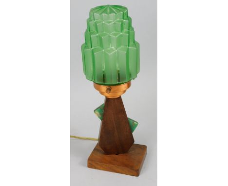 An Art Deco mahogany table lamp,  with a jelly mould type green glass shade, copper mount, the base mounted with coloured Bak