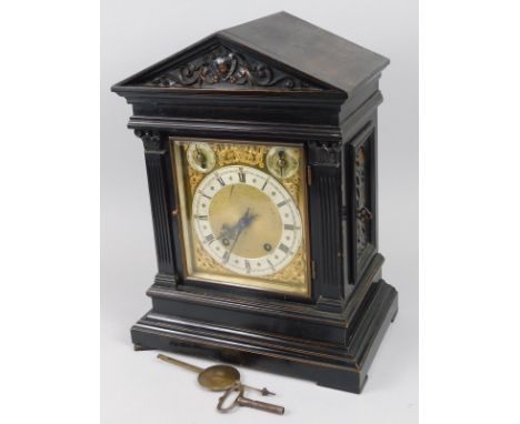 A late 19th/early 20thC ebonised mantel clock, with brass and silvered dial, the portico shaped case with reeded pilasters, t