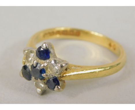 An 18ct gold dress ring, formed in floral cluster with tiny sapphire and diamonds, in the abstract style, with pierced should