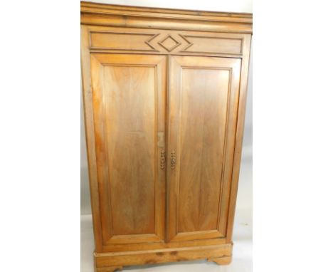 A 19thC French fruitwood armoire, with a moulded cornice, above two panelled doors, on canted bracket feet, 211cm high, 59cm 