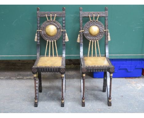 PAIR OF EBONISED WALNUT CHAIRS BY CARLO BUGATTI, PROFUSELY INLAID WITH PEWTER & WHITE WOOD, WITH APPLIED HAND BEATEN COPPER &