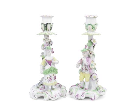 A pair of Derby 'Pale Family' candlestick figures, circa 1756-58Modelled as a farmer and his wife, each standing before a tru