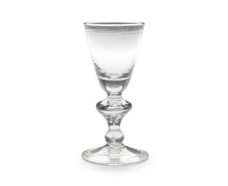 A heavy baluster wine glass, circa 1710-15The round funnel bowl with a solid base, the stem with a wide teared angular knop, 