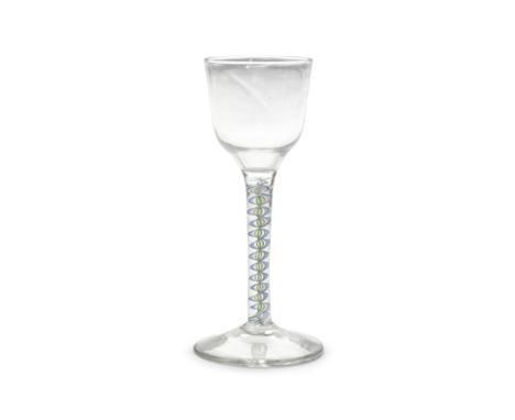 An exceptionally rare colour twist wine glass, circa 1765The ogee bowl set on a stem comprising a thirteen-ply multi-coloured