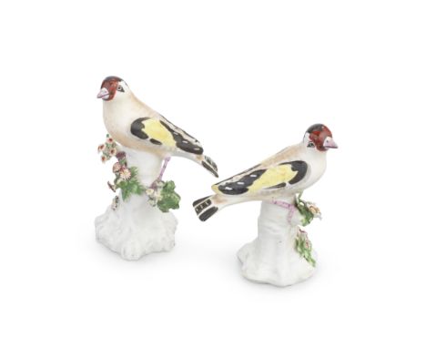 A pair of Derby models of goldfinches, circa 1770 The birds with naturalistically coloured plumage, both perched on tree stum