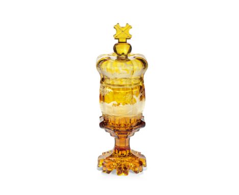 A Bohemian amber-stained goblet and crown cover, circa 1840-50 The barrel-shaped bowl cut with eight broad panels, engraved w