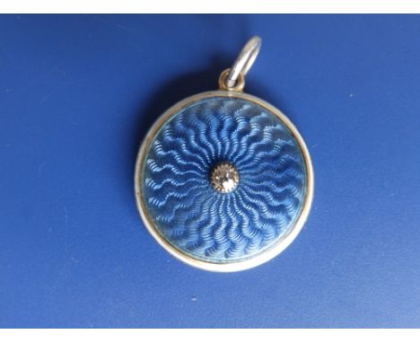 An enamelled '15ct' circular locket, the cover decorated in blue guilloche enamel with white border, a single small old cut d