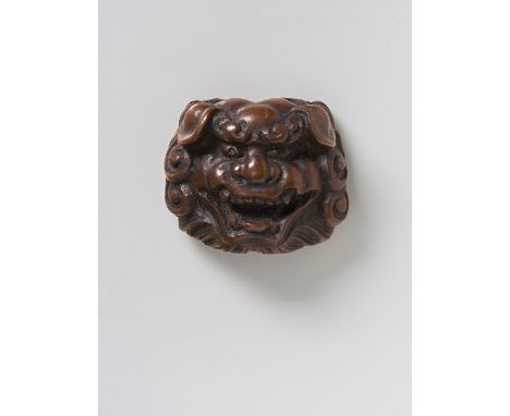 A JAPANESE MASK NETSUKE OF SHISHI, LATE 19TH CENTURYwood, with signature ‘Tomokazu’3.6cm high Peter E. Müller Japanese Mask C