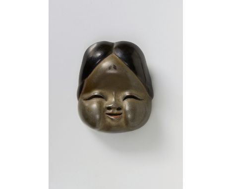 A JAPANESE MASK NETSUKE OF OKAME, BY SHIBATA (IKEDA) SHINSAI, 19TH CENTURYsilver and black lacquered wood, signed ‘Shinsa’4.4