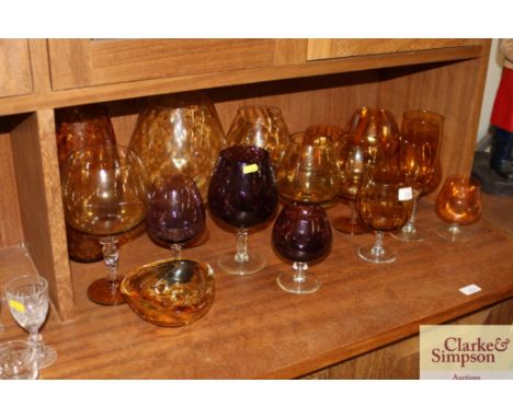 A quantity of amber and amethyst tinted glass brandy balloons, goblets, etc.