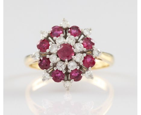 An 18ct yellow gold ruby and diamond tiered cluster ring, set with a central round cut ruby, measuring approx. 3mm, surrounde