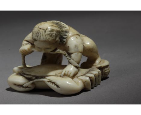 A 19th century Japanese netsuke. Signed Hidekazu (Shuichi), in carved ivory portraying 'Kintaro' on a tied crab, 2,52x3,44x2,