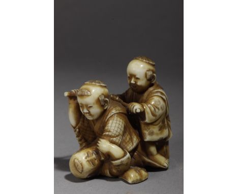 A Japanese netsuke from Meiji period circa 1860-1880. Not signed. In carved elephant ivory and lacquer, portraying a group of