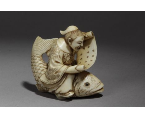 A late 19th century Japanese netsuke from Meiji period. Signed Munetoshi. In carved elephant ivory with horn eyes depicting S