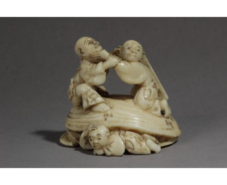 A mid 19th century Japanese netsuke from Edo period. Signed Masatsugu. In carved elephant ivory portraying a group of figures