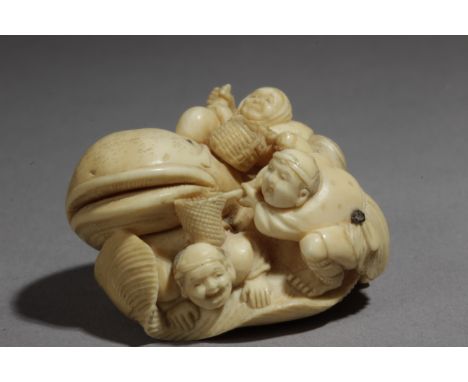 A late 19th century Japanese netsuke from Meiji period. Signed Chokusai Con Kakihan. In carved ivory and horn depicting a gro