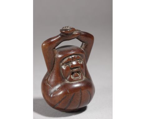 A 19th century Japanese netsuke from Edo period. Not signed. In carved wood portraying a Yuki daruma going out from a fruit, 