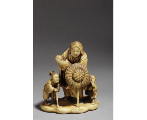 A mid 19th century Japanese netsuke okimono from Edo period. Signed Gyokuzan. In carved ivory portraying a group of figures c