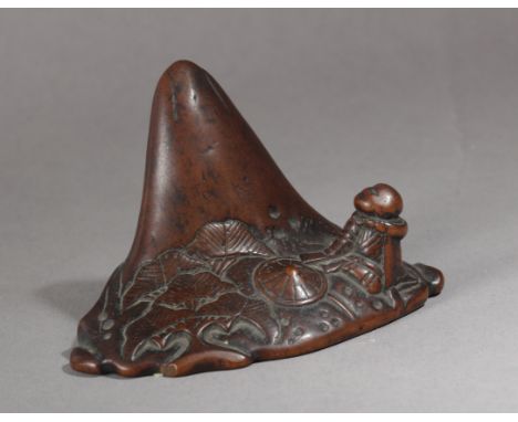 A 19th century Japanese netsuke. Not signed. In carved wood portraying a child sat at the base of a mountain, 3,74x5,81x2,99 