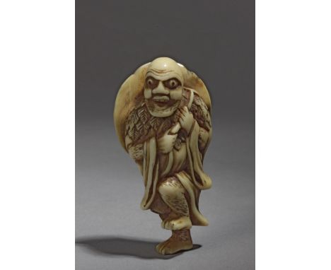 An 18th century Japanese netsuke from Edo period. Not signed. In carved ivory and horn portraying a standing 'Sennin' holding