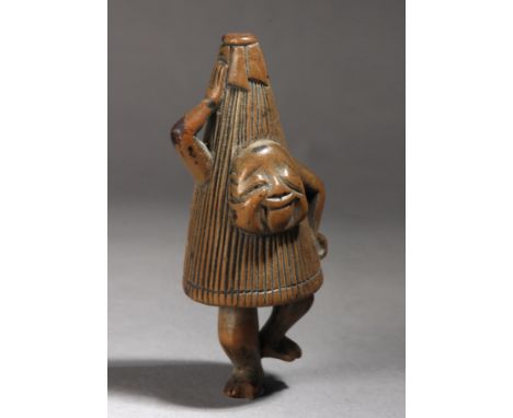 A 19th century Japanese netsuke. Not signed. In carved wood portraying a standing actor wearing an umbrella costume and danci