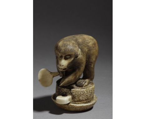 A 19th century Japanese netsuke. Signed Kiyotora. In carved elephant ivory portraying a monkey on a wine press and grabbing a