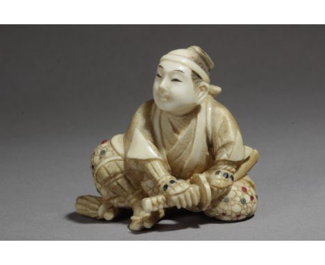 A Japanese netsuke from Meiji period circa 1900. Signed Mitsuaki or Komin. In carved ivory with gemstones inlaid portraying a