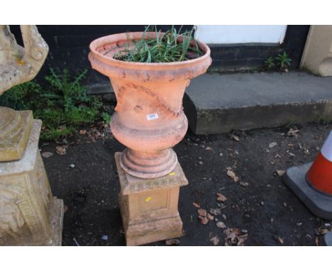 A terracotta planter raised on plinths