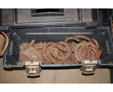 A tool box and contents with various horse shoes