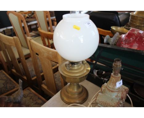 A brass oil lamp with milk glass shade