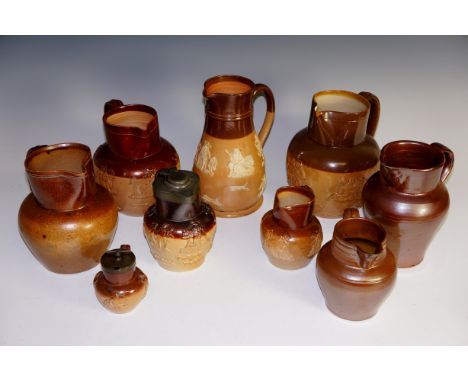 A quantity of Doulton and other salt glazed jugs, some relief moulded with hunting and other scenes, two pewter lidded (qty)