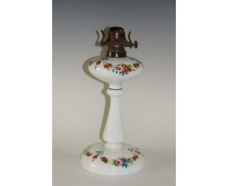 A Victorian milk glass oil lamp decorated overall with ribbon tied floral swags, 29 cm high, circa 1870 (lacking chimney and 