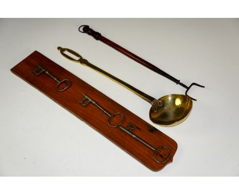 Three iron keys on oak plaque, a 19th Century brass ladle, a toasting fork with tapered mahogany handle (qty)