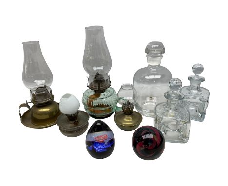 Two Caithness paperweights, together with four hand held oil lamps and three decanters  