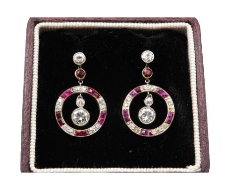 A PAIR OF RUBY AND DIAMOND EARRINGS Each designed as an openwork hoop alternately set with calibré-cut rubies and old brillia