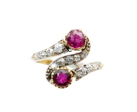 A RUBY AND DIAMOND CROSSOVER RINGOf swirling design, set with a duo of circular-cut rubies, with old brilliant-cut diamond hi