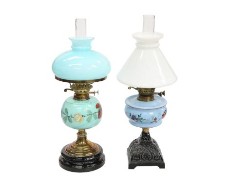 TWO VICTORIAN OIL LAMPS, each with painted glass reservoir, the first with cast iron base, the second with brass stem. (2) Fi