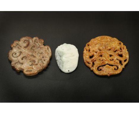 A CHINESE JADE PENDANT, carved with a dragon, 5cm by 3.6cm; together with TWO CHINESE CARVED PLAQUES. (3)In very good conditi