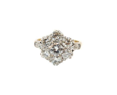 A DIAMOND CLUSTER RINGOf floraform design, set throughout with brilliant-cut diamonds, between openwork foliate shoulders, to