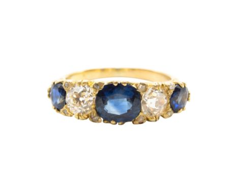 A SAPPHIRE AND DIAMOND FIVE-STONE RING The carved scrolling hoop claw-set with three oval-cut sapphires and two old brilliant